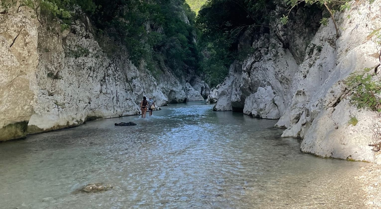 Crystal-clear turquoise water of the Acheron River flowing between narrow canyon walls