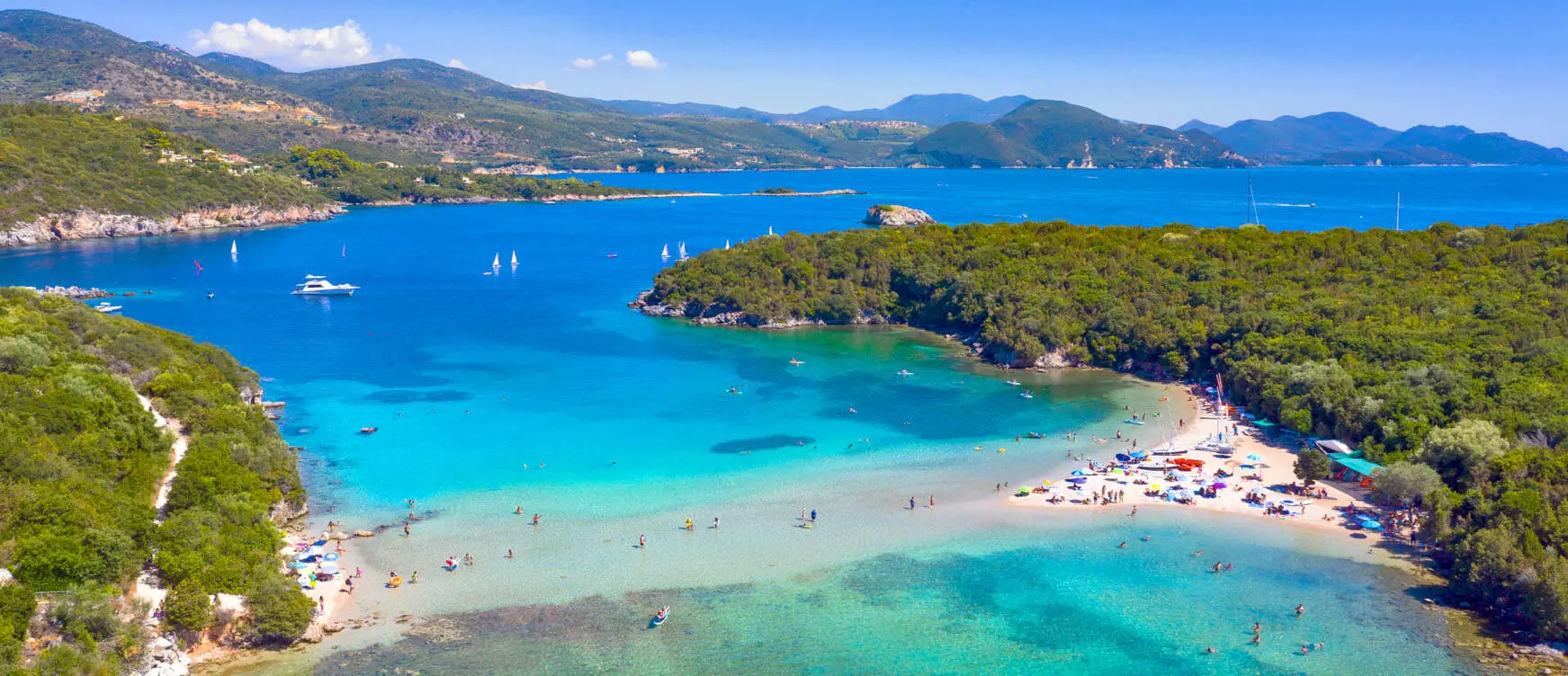 Aerial view of Syvota harbour with turquoise water and small fishing boats