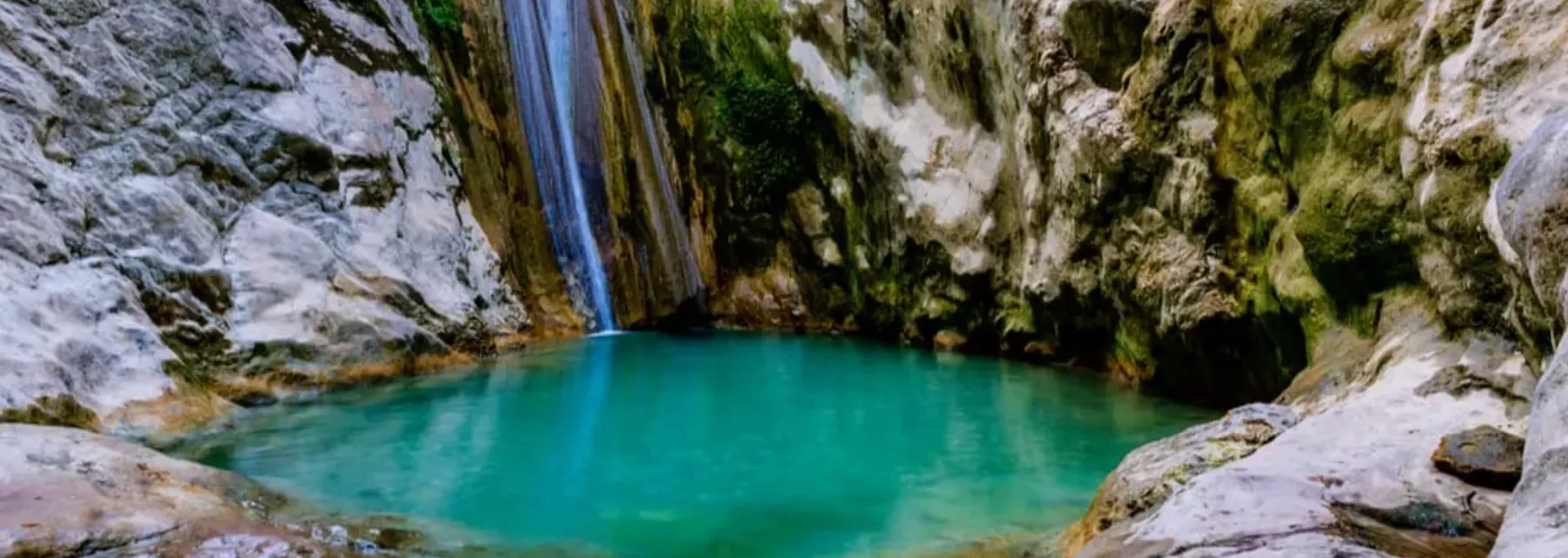 The main Nydri waterfall cascading into a pool in a green gorge, Lefkada